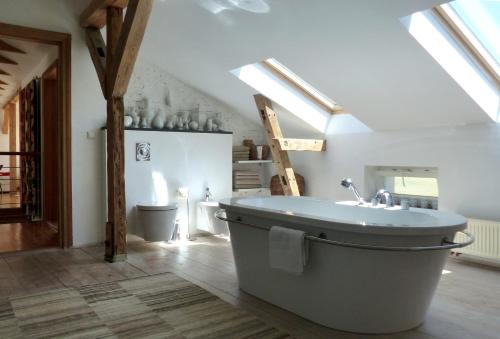 MelzowVilla am Trumpf - Design-Appartements im Naturgarten am See的阁楼设有带大浴缸的浴室