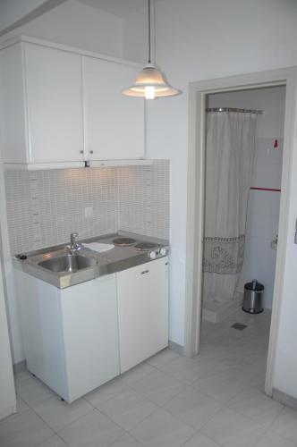 锡蒂亚Portobelis Apartments的白色的厨房设有水槽和淋浴