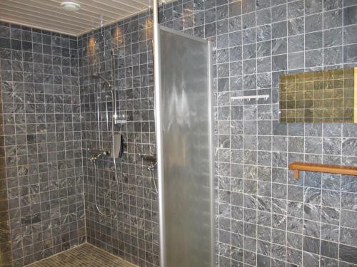 萨利色尔卡Lapin Kutsu Log Cabins的浴室设有蓝色瓷砖淋浴。