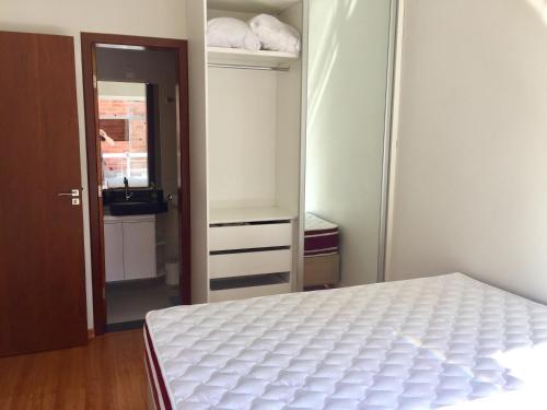 迪亚曼蒂纳Apartamento 3 Quartos com varanda的卧室配有白色的床和衣柜。