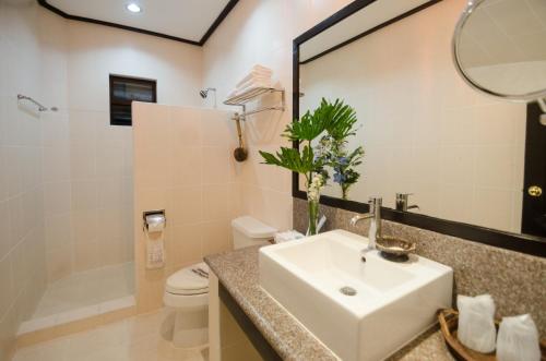 长滩岛海风度假酒店的一间带水槽、卫生间和镜子的浴室