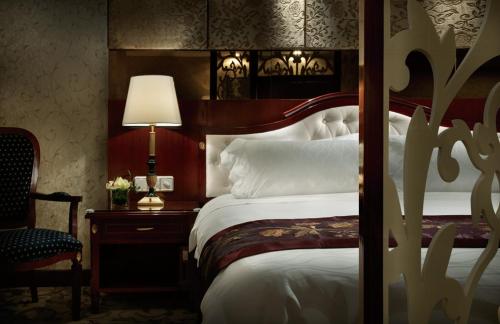 武汉武汉天禄华美达广场酒店的一间卧室配有一张床和一张带台灯的桌子
