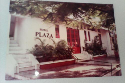 JālgaonHotel Plaza (BOOKING FOR FOREIGN TOURIST ONLY)的一座白色的建筑,有红色的门和一些植物