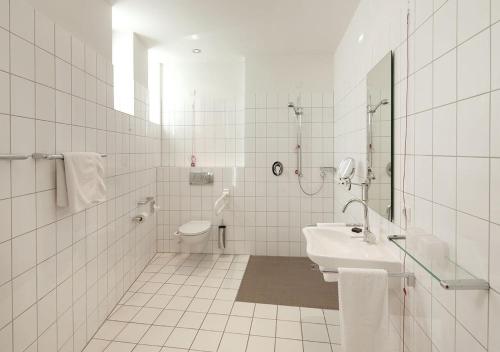 施韦特Katholische Akademie Schwerte的白色的浴室设有水槽和卫生间。