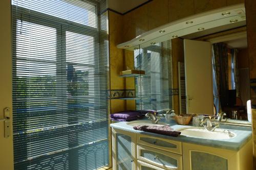 翁弗勒尔勤勉酒店的一间带水槽和镜子的浴室以及窗户。