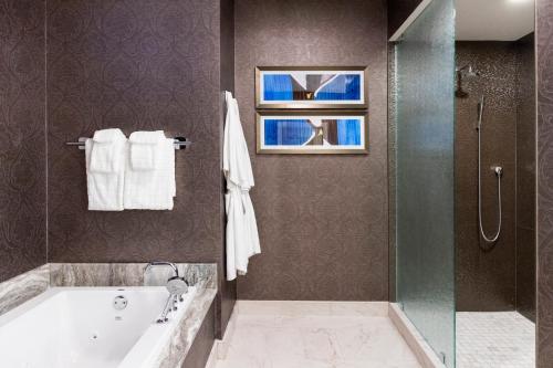 新奥尔良荣格酒店的带浴缸和玻璃淋浴间的浴室。
