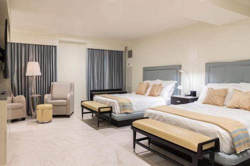 新奥尔良荣格酒店的酒店客房,配有两张床和椅子