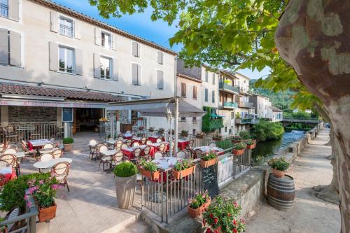 科洛布里埃Hotel Restaurant des Maures的户外餐厅设有桌椅,河流