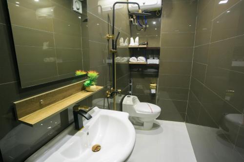 海防范汉酒店的浴室配有白色水槽和卫生间。
