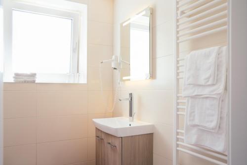 Sankt Martin im Sulmtal格斯玛瑞提旅馆的白色的浴室设有水槽和镜子