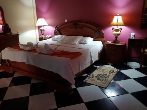 塔巴廷加塔卡纳酒店的一间卧室设有一张大床,铺有 ⁇ 格地板