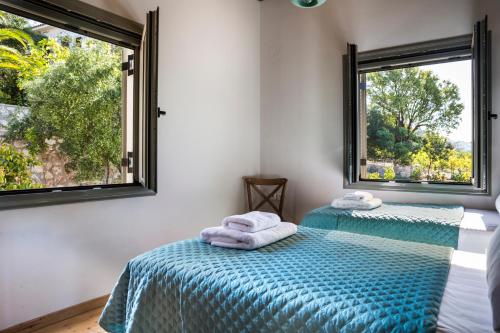 AnomeriáMyrtos Bay Apartments的带2扇窗户的客房内的2张床
