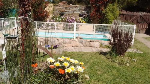 波特雷罗德洛斯弗内斯Cabañas Molinos de Vientos的鲜花盛开的花园和游泳池