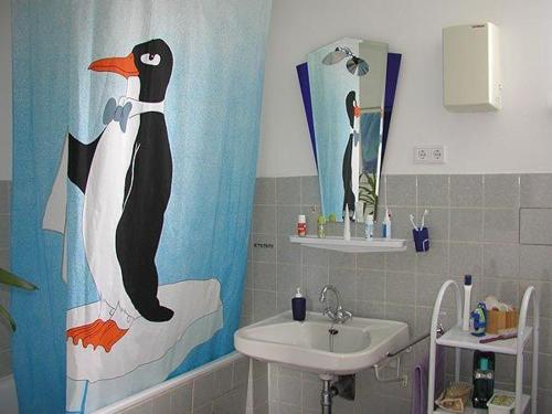 SterupFerienwohnung-im-historischen-Kaufhaus-Angeln的一间带企鹅淋浴帘和水槽的浴室