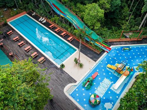 甘榜布提尔婆罗洲热带雨林度假村的享有带水上公园的游泳池的顶部景致