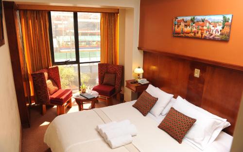 库斯科Hotel Waynapicchu的酒店客房带床、椅子和窗户