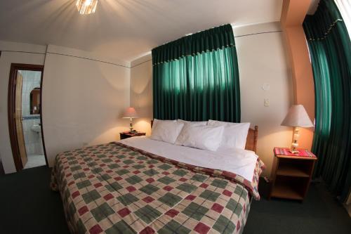普诺Hotel T'ika的酒店客房,配有一张带绿帘的床
