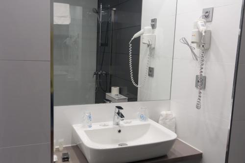 马贝拉Ona Marbella Inn的白色的浴室设有水槽和电话
