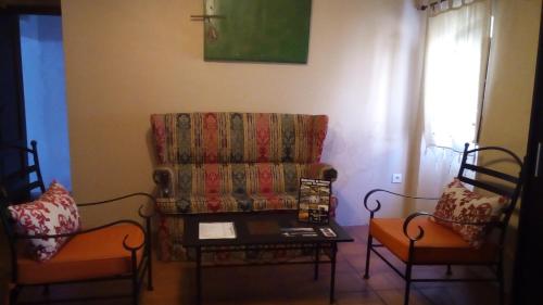 马尔帕尔蒂达德卡塞雷斯卡萨乡间玛丽亚旅馆的客厅配有沙发和两把椅子