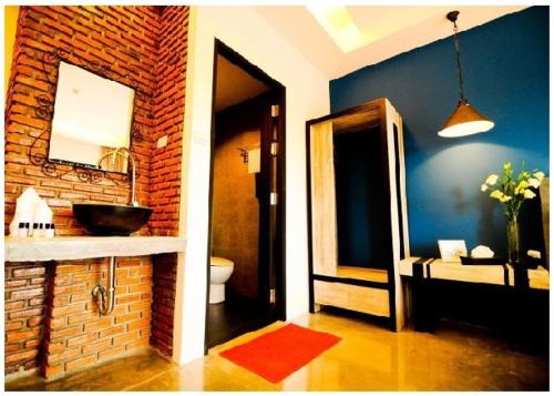 安帕瓦Amphawa Nanon Hotel的一间带水槽和砖墙的浴室