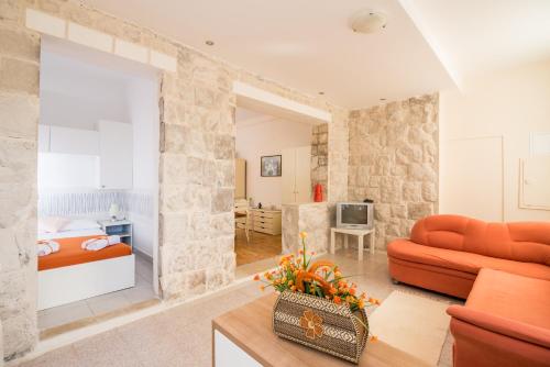 格鲁达Friendly Apartments的一间带橙色沙发的客厅和一间卧室