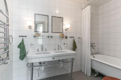 维默比Storebro Herrgård的白色的浴室设有水槽和浴缸。