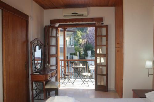 卡科佩特里亚Maritsa Lodge的一间卧室设有一扇门,可通往带桌子的庭院。