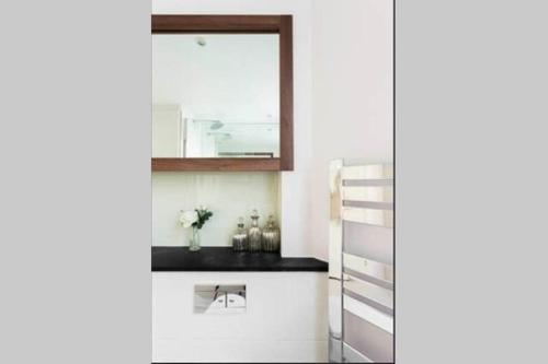 伦敦Heart of Mayfair - Stunning Apartment的一间带镜子和梯子的浴室
