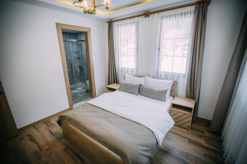 乌宗Nova Uzungöl的一间卧室配有带白色床单和枕头的床。