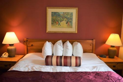 威奇托威奇托贝蒙特套房酒店的一间卧室配有一张带白色枕头的床和两盏灯。