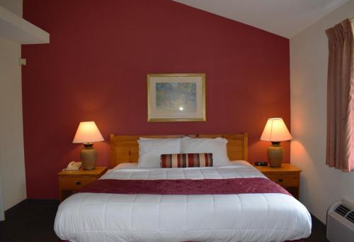 威奇托威奇托贝蒙特套房酒店的一间卧室设有一张带红色墙壁的大床