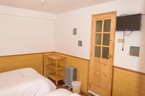 普诺堂约赛住宿加早餐的卧室配有一张床,墙上配有电视。