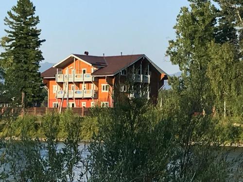 NovosnezhnayaUsadba Novosnezhka的河边的大房子