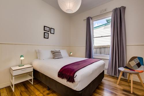 霍巴特络赛哈温度假屋的一间卧室设有一张大床和一个窗户。