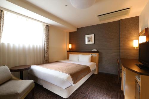 札幌札幌法华俱乐部酒店的酒店客房,配有床和电视