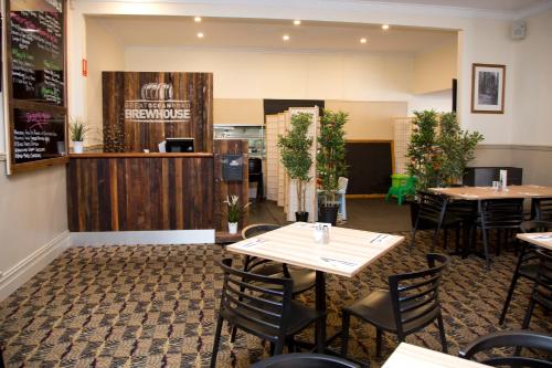 阿波罗湾Great Ocean Road Brewhouse Apollo Bay的一间带桌椅和柜台的餐厅