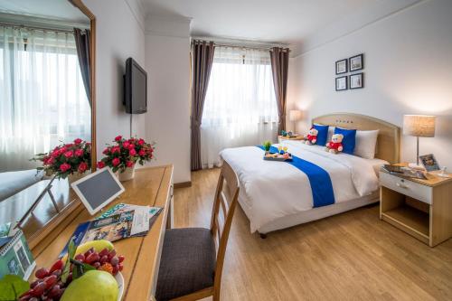 河内玫瑰园公寓的酒店客房配有一张床铺、一张桌子和一张书桌。