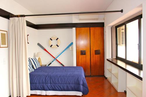塞辛布拉Akisol Sesimbra Beach的一间卧室配有一张蓝色床单,墙上挂着棒球棒