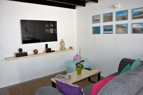 纳萨雷特Apartamento Las Palmeras Nazaret的客厅配有沙发和墙上的电视