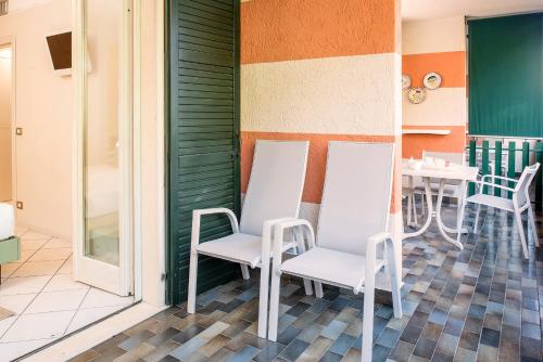 巴多利诺Blue Lake Residence - Bardolino的庭院配有白色的椅子和桌子