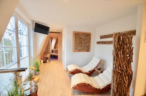 青斯特Villa Strandblick 10的客厅配有白色椅子和电视
