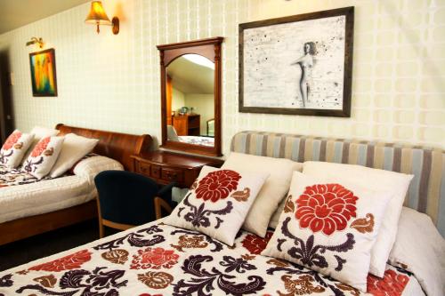 考纳斯帕匝里斯公园酒店的一间卧室配有一张床和一面镜子,另一间卧室配有一张带枕头的床