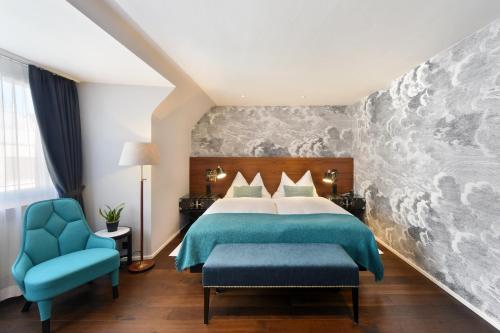 苏黎世苏黎世城市设计与生活酒店的一间卧室配有一张床和一张蓝色椅子