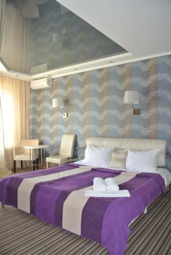 基辅Mini Hotel on Poznyaky的一间卧室配有一张大床和两条毛巾