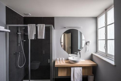 埃武拉埃武拉中心思黛酒店的浴室配有盥洗盆和带镜子的淋浴