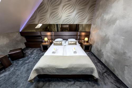 凯奇凯梅特Royal Apartments Hotel Kecskemét的一间卧室配有一张带2个床头柜的大床