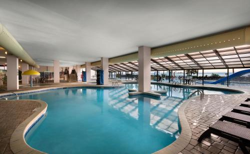 默特尔比奇布瑞克度假村酒店的一座带长椅的大楼内的大型游泳池