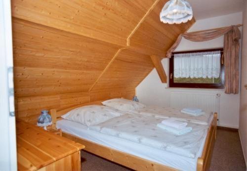 Neundorf李奇特度假旅馆的木天花板的客房内的一张床位