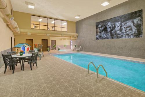 奇斯顿Rushmore Express & Suites的一座配有桌椅的酒店游泳池