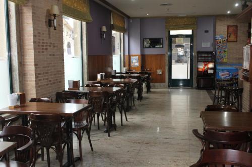 蓬费拉达埃尔卡斯特洛酒店的用餐室配有木桌和椅子